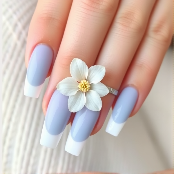 A French tip acrylic nail that’s is baby blue with a white underline under the blue French with a flower on the ring finger