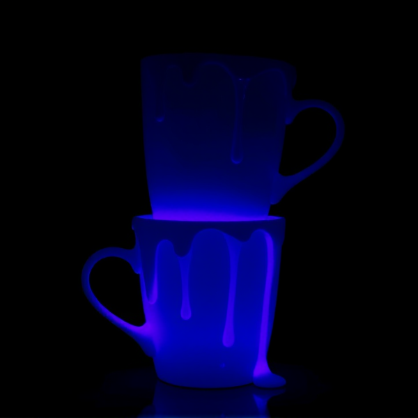 Two white cups stacked with luminescent purple liquid dripping down the sides in a stylized manner, under moody atmospheric lighting that accentuates the glow
